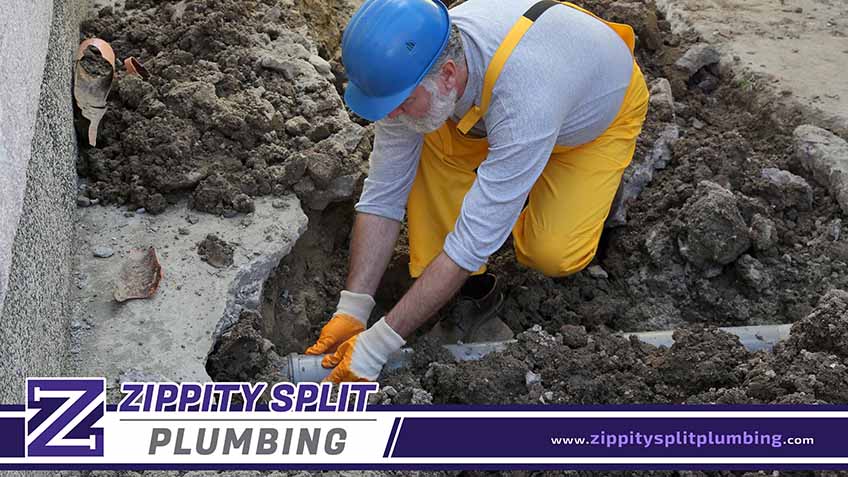 Plumber Fixing Sewerage Pipe at Construction Site