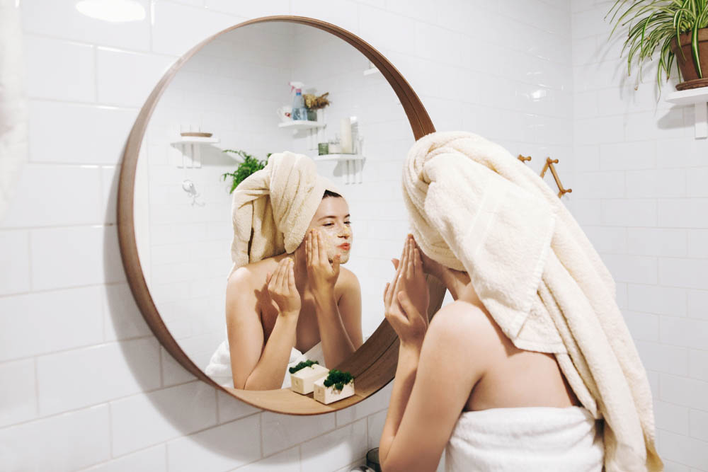 a person using a facial cleanser and facing the mirror on top of the sink Phoenix, AZ