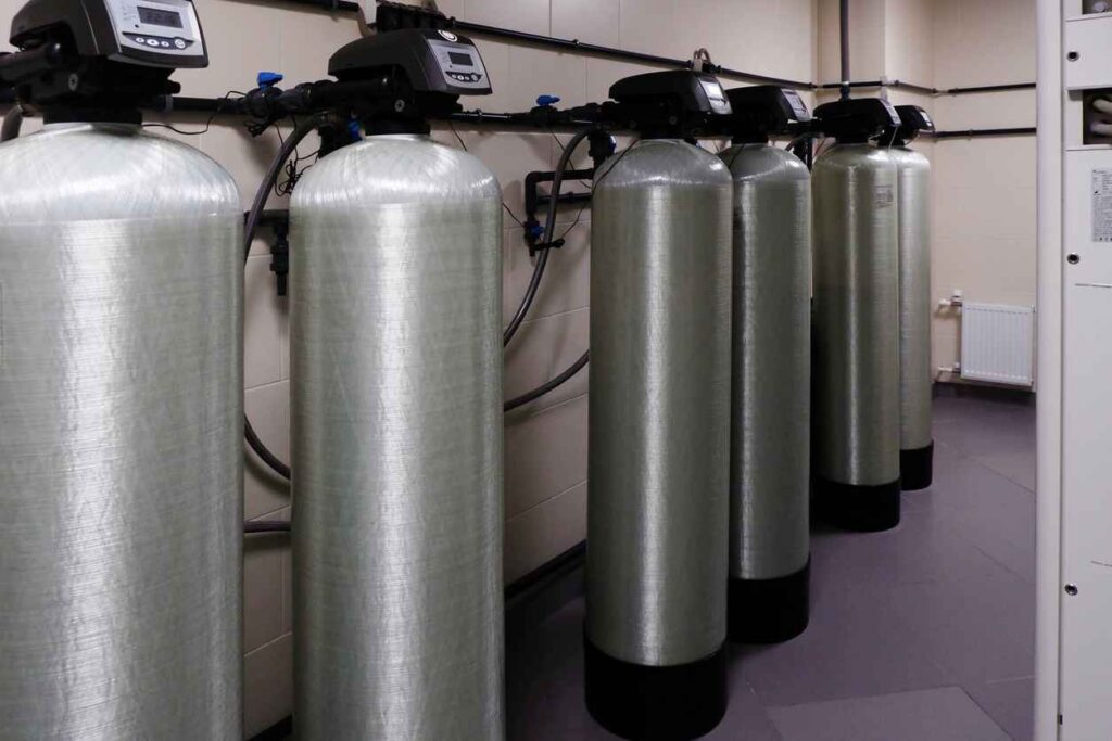 several water softener filters for water stand in a row.