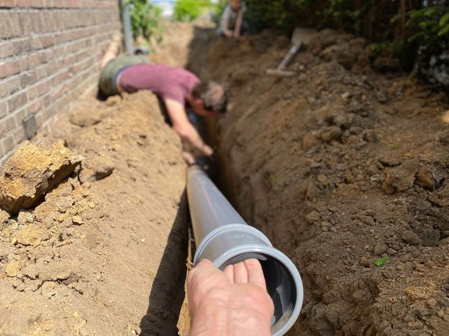 Plumbers repairing sewer line at a home