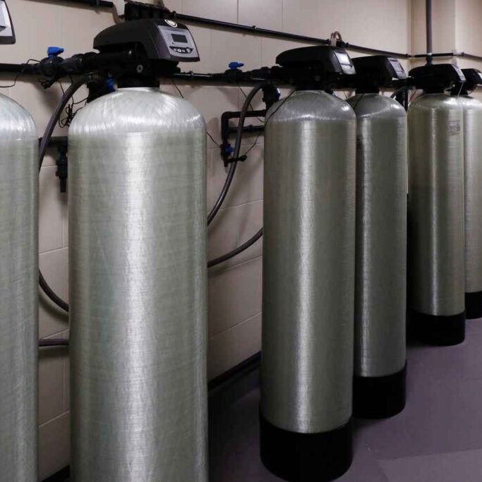several water softener filters for water stand in a row.